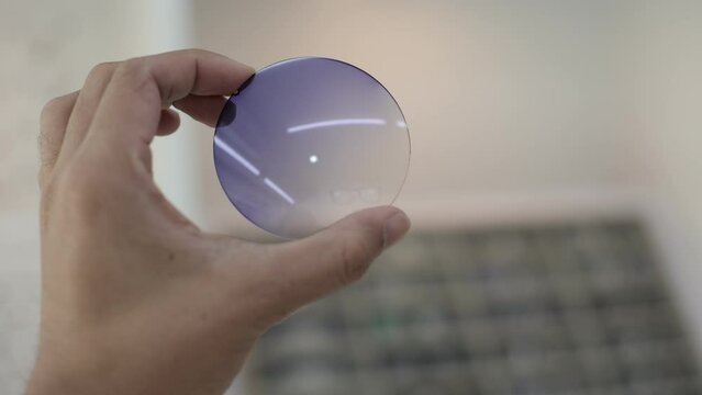 hand holding glasses lenses in optical store 