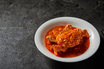 traditional chinese wok fried seafood fresh big meat crab with chilli spicy salted egg yolk cheese cream sauce in plate on dark stone table asian cafe hotel luxury halal food restaurant banquet menu