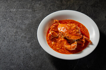 traditional chinese wok fried seafood fresh big meat crab with chilli spicy salted egg yolk cheese cream sauce in plate on dark stone table asian cafe hotel luxury halal food restaurant banquet menu