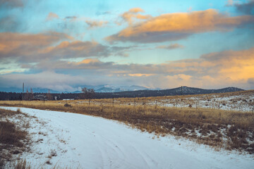 winter landscape with snow, foothills, and mountains rising in the background