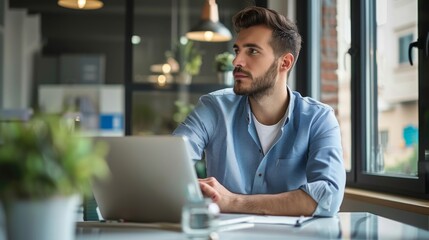 A focused manager sits in a quiet office, having a virtual meeting on a laptop with remote team members, ensuring continuous collaboration and connectivity in a distributed workforce