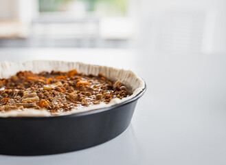 plant-based lentil and pumpkin pie with filling just poured into the pastry before cooking it