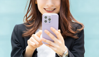 スマートフォンを操作をする笑顔のビジネスウーマン © Trickster*