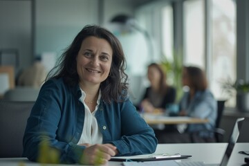 Obraz premium Young successful businesswoman at corporate office looking at camera. Office business portrait