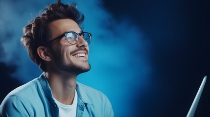 Obraz premium Young smiling man using laptop