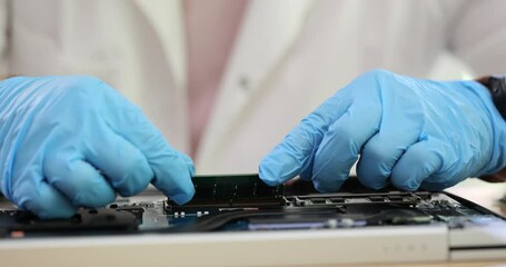 Laptop computer and motherboard repair engineer installs RAM in laptop