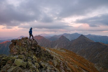 Obraz premium Beautiful mountains at sunset. Man who enjoys a break look at the top of the mountain at sunset adventure travel.