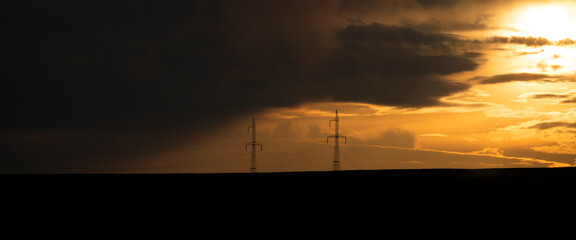 Silhouette of high voltage electric tower on sunset time.