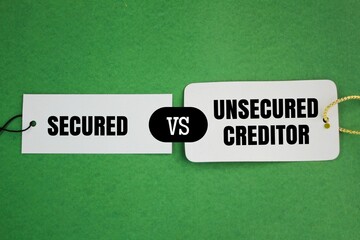 two white papers with the words secured vs unsecured creditor. creditor concept