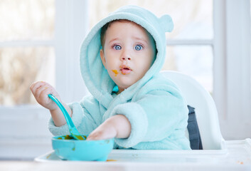 Baby, food and mess in feeding chair with eating, learning and portrait for health, nutrition and care in family home. Infant child, hungry and container with breakfast, development and diet in house