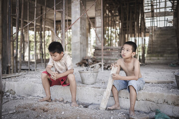 Two poor children are forced to work in construction. Poor children, poverty, Child labor, World Day Against Child Labour concept.