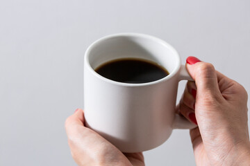 コーヒーカップを持つ女性の手元