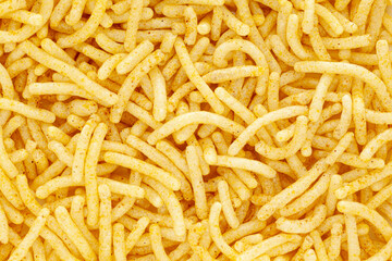 Close-up of Indian spicy snacks (Namkeen) - Bikaneri Besan Bhujia. Full frame, wallpaper. Top view.