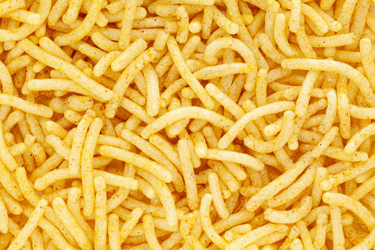 Close-up of Indian spicy snacks (Namkeen) - Bikaneri Besan Bhujia. Full frame, wallpaper. Top view.
