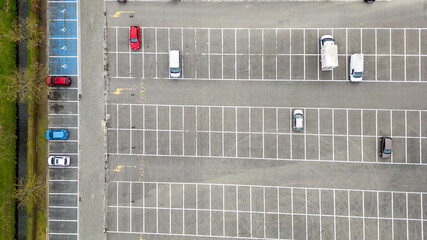 The view from above shows a parking lot packed with parked cars. The scene features various cars...