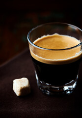 Coffee in glass cup on dark background. Close up. Copy space