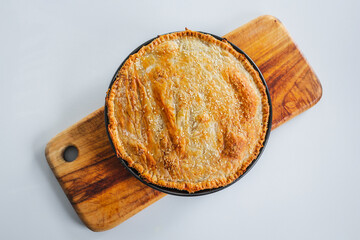 homemade round puff pastry pie in style of a sheperd's pie with sesame seeds topping just out of...