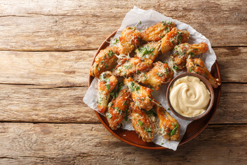 Classic Garlic Parmesan Butter Chicken Wings served with mayonnaise close-up in a plate on the...