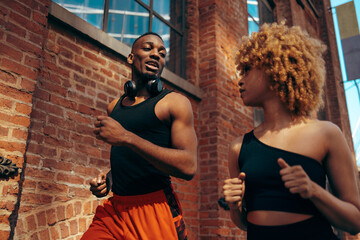 A young man and a young woman jogging together