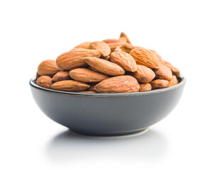 Peeled almond nuts in bowl isolated on white background.
