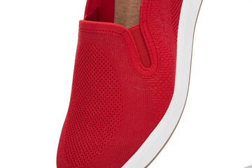 Close-up view of a vibrant red slip-on shoe, featuring intricate mesh texture and fine stitching,...