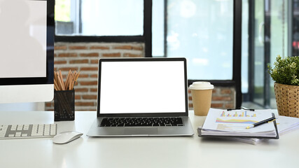 Front view laptop, financial document, coffee cup and stationery on white table