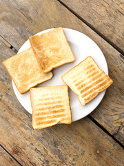 Toasts in a plate on a wooden table