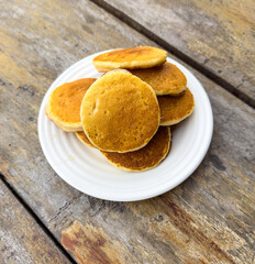 Pancakes in a plate on a wooden table