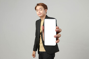 asian business man holding mobile phone and showing blank screen with dislike unhappy expression on...
