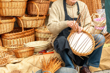 hands of a craftsman making a wicker basket, traditional crafts concept