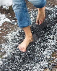 people walk with their feet on hot coals as a background.