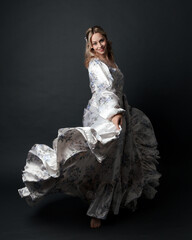 portrait of beautiful blonde female model wearing romantic historical gown white bridal floral...