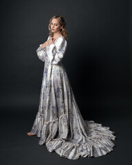 portrait of beautiful blonde female model wearing romantic historical gown white bridal floral...