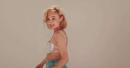 Beautiful woman with blond curly hair in jeans.
