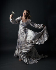 portrait of beautiful blonde female model wearing romantic historical gown white bridal floral...