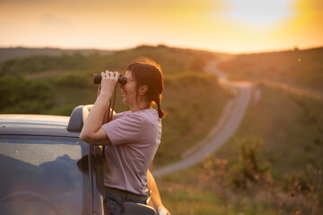 Happy woman looking through binoculars