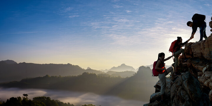 Asian hiking help each other on mountains