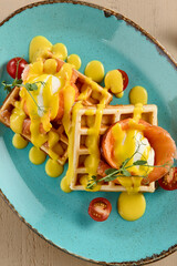 Elegant waffle topped with smoked salmon, a poached egg, and hollandaise sauce, served on a light...