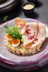 Elegant Olivier salad with mortadella, quail egg, and red caviar, a gourmet twist on a classic dish