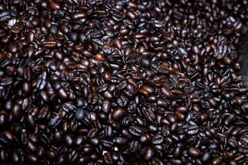 Obraz premium Close up of roasted coffee beans surface rotate in a spinning roaster mashine for background
