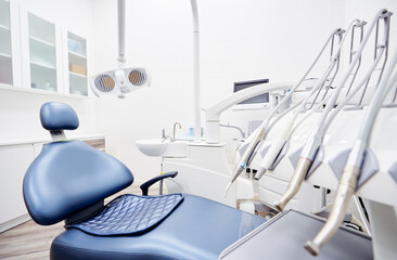 Dental equipment in dentist office in new modern stomatological clinic room. Background of dental chair and accessories used by dentists in blue and white.