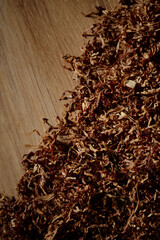 Cut dried tobacco leaves on wooden background with copyspace