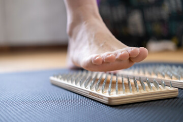 SADHU boards for standing on metal nails. A woman's foot on boards with nails. A female yogi. a...