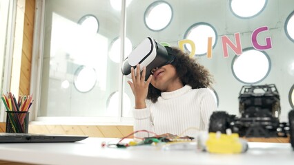 Creative girl wearing VR headset to learning in metaverse. Funny kid enjoy to wearing AI headset...