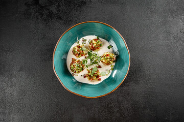 Scallops in a creamy mousse with tomato salsa, delicately plated in a turquoise dish