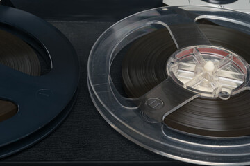 two round reels of magnetic film on an old tape recorder, background