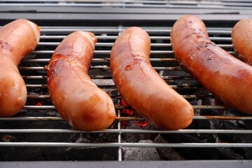 Many sausages grilling on charcoal oven