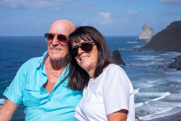 Tender senior couple posing for memory photo enjoying seaside holidays at the famous Benijo beach in Tenerife  - travel and vacation, carefree retirement lifestyle concept