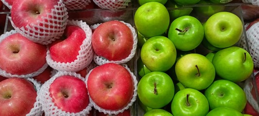 several types of apples in baskets of various colors