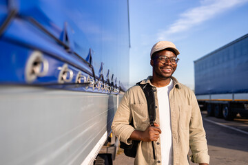 Truck driver with backpack standing by vehicle trailer coming to work.